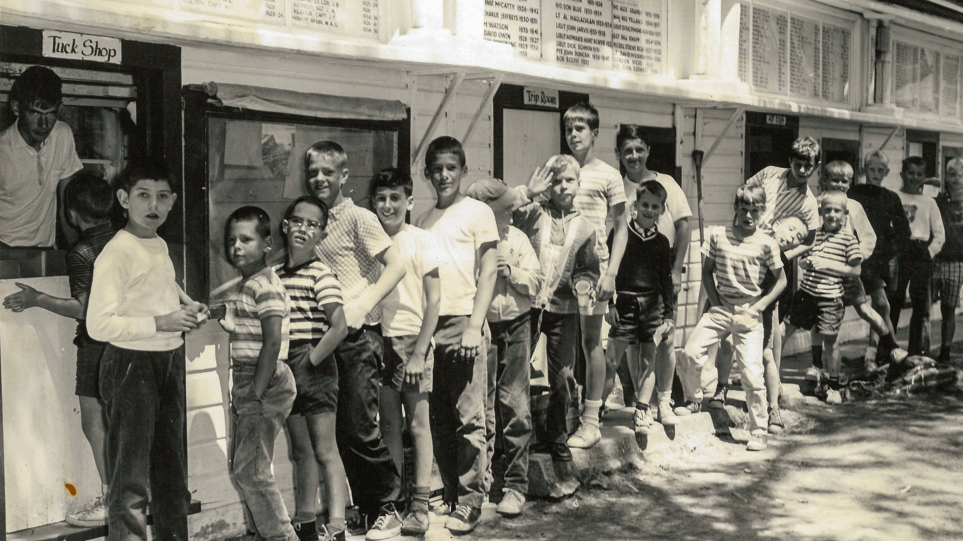 Vintage photo of young boys standing in a line outside.
