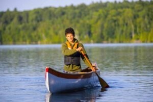 Canoeist paddling alone on calm lake