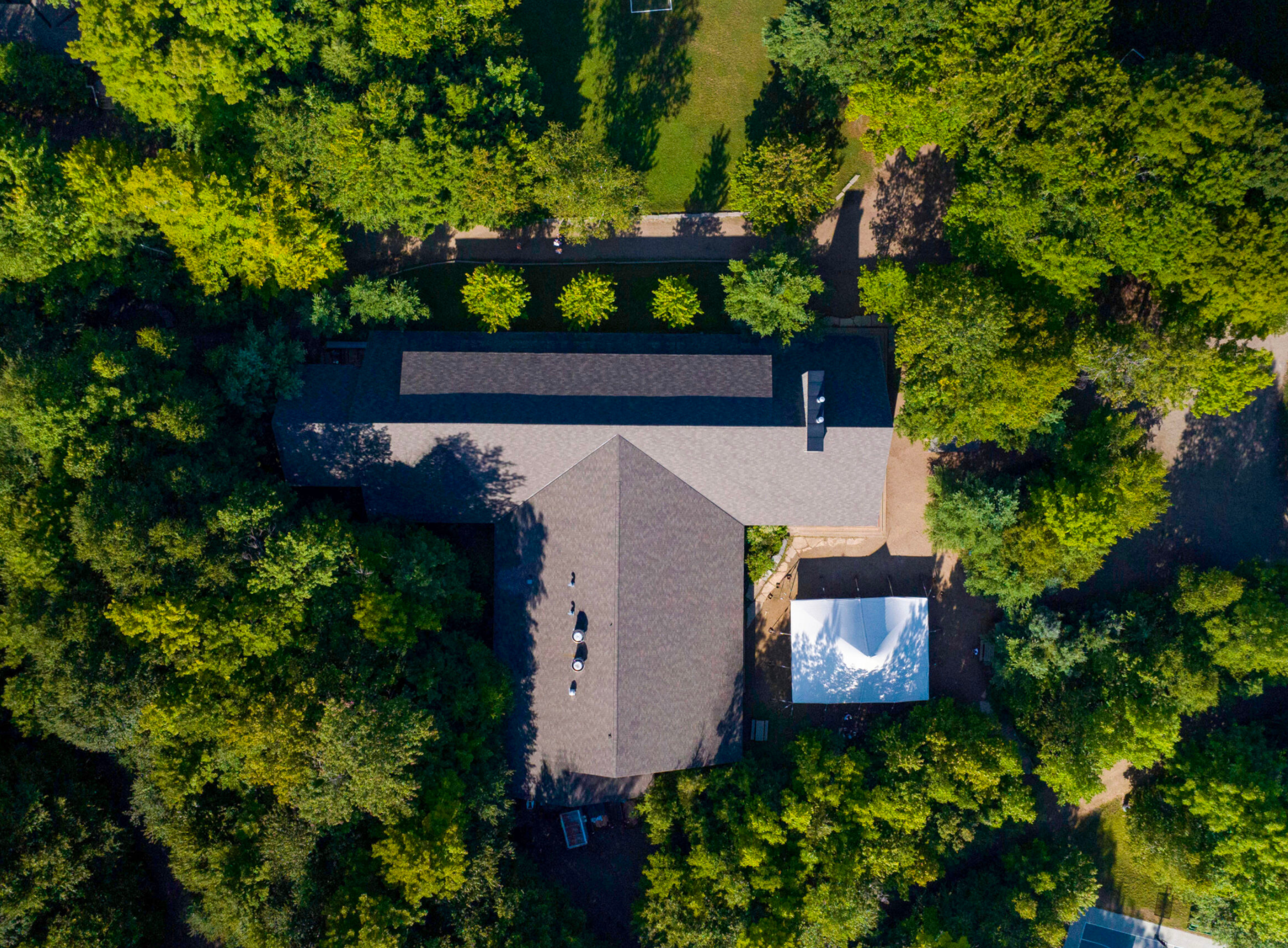 Aerial shot of a large camp building surrounded by trees.