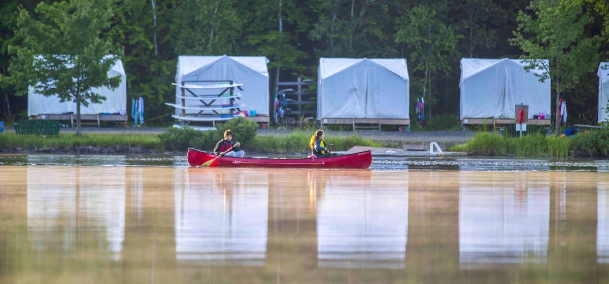 Red canoe floating on a calm lake.