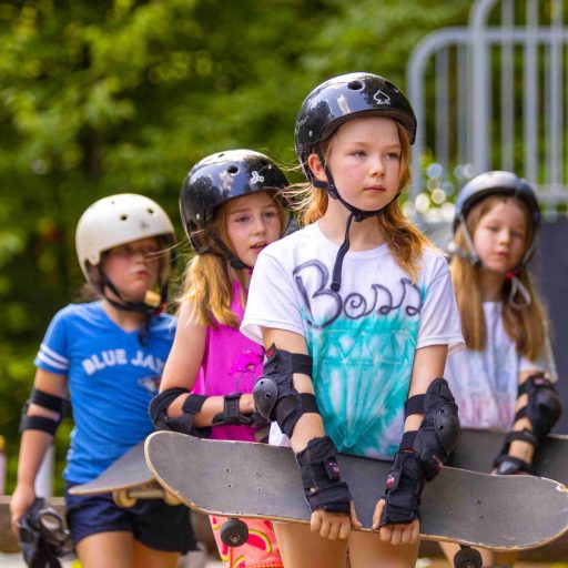 Young campers wearing helmets and safety pads.