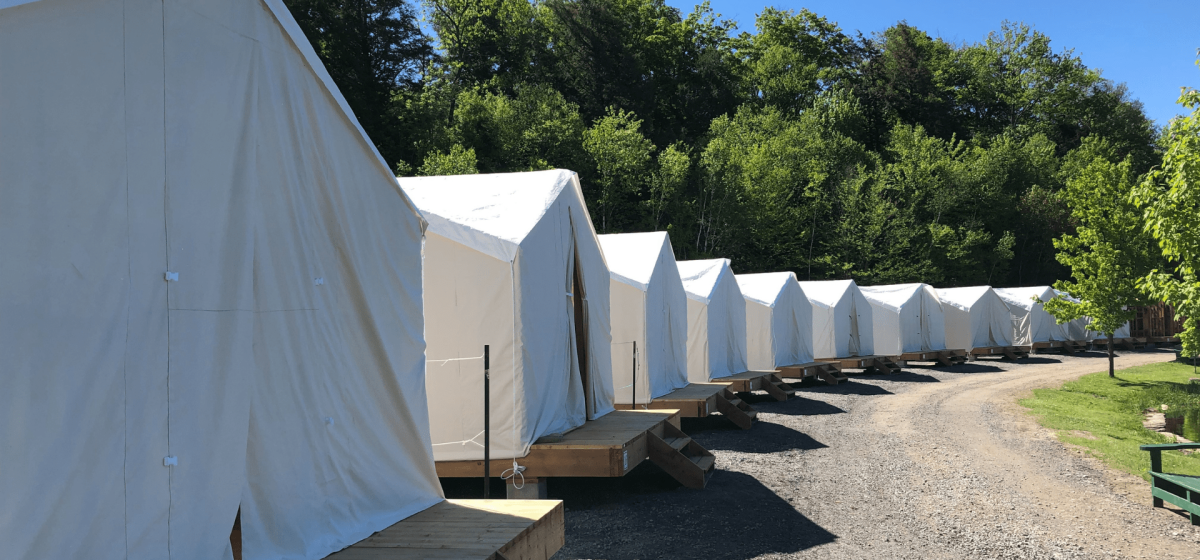 Row of white canvas tents on platforms.